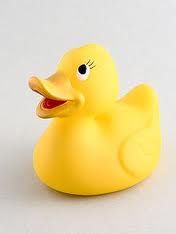 a yellow rubber ducky with its mouth open and tongue out on a white surface