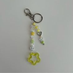 a keychain with beads and charms attached to it on a white table top