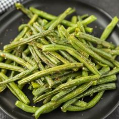 cooked green beans on a black plate