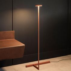 a lamp that is on the ground next to a desk and chair in a room