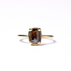 a yellow gold ring with a large brown stone in the center on a white background