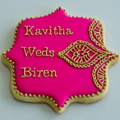 a decorated cookie with the words kavitha weds biren on it