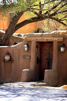 an adobe - style house with potted plants on the outside