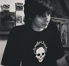 a young man wearing a black shirt with a skull on it