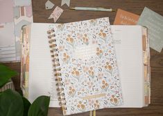 an open planner book sitting on top of a wooden table