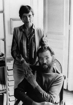 an old black and white photo of a man getting his hair cut by a woman