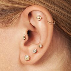 a close up of a person's ear with three different piercings on it