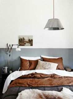 an image of a bed with brown and white sheets on it, in the same room