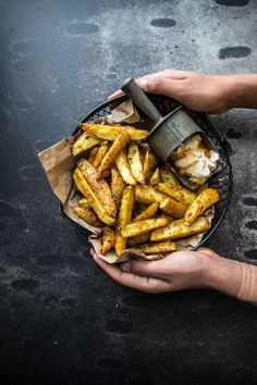 a person holding a basket filled with french fries