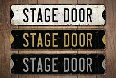 three black and white signs on wooden planks that read stage door, stage door