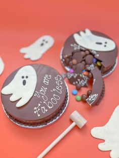 chocolate covered cookies with ghost decorations and candy sticks