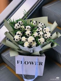 a bouquet of white flowers sitting on top of an airport luggage bag with a sign that says flower