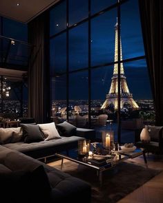 a living room filled with furniture and a view of the eiffel tower at night