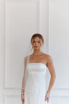 a woman wearing a white wedding dress and veil