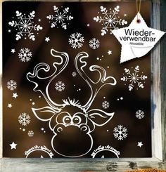 a window with snowflakes on it and a reindeer drawn on the glass in front