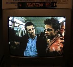 two men standing next to each other in front of a tv with the words fightclub on it