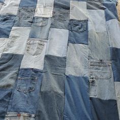 an old patchwork blanket with blue and grey patches on the bottom, sitting on top of a rug