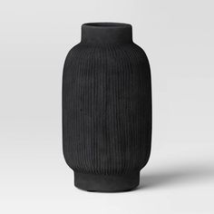 a black vase sitting on top of a white table