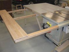 a workbench with a table sawing on it in a garage next to a car