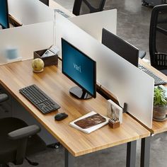 two computer screens sitting on top of a desk next to each other in an office