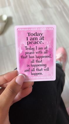 a person holding up a pink card that says today i am at peace