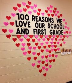 a bulletin board with hearts on it and the words 100 reasons we love our school and first grade