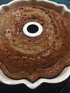 a bundt cake in a white pan on a cooling rack with a hole in the middle