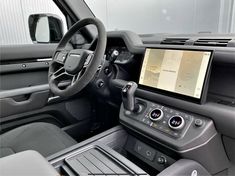 the interior of a vehicle with dashboard, steering wheel and touch screen monitor on display