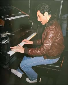 a man sitting at a piano with his hands on the keys