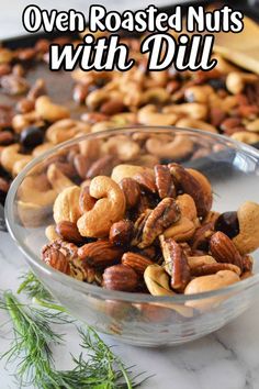 nuts in a glass bowl with rosemary sprigs on the side and text overlay that reads oven roasted nuts with dill