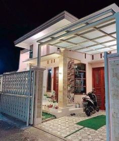 a motorcycle is parked in front of a house with a pergolated roof over it