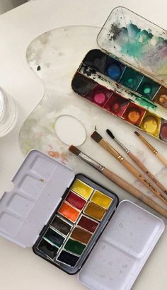 an artist's palettes and watercolor paints on a table