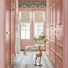 a hallway with pink walls and white flooring