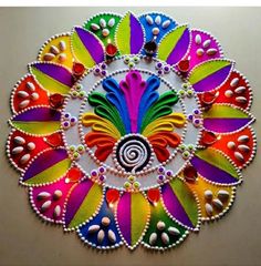 a colorful circular design made with beads and bead work on a table top or wall