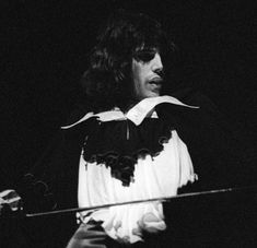 black and white photograph of a woman with long hair in front of a microphone on stage