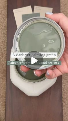 a person holding a paint can in their hand with the words, a dark yet calming green