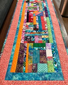 the table runner is made with colorful fabrics