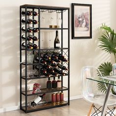 a wine rack filled with bottles and glasses on top of a wooden floor next to a dining room table