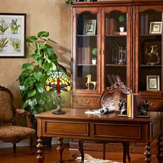 a living room with a chair, desk and bookshelf filled with items on top of it