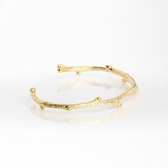 a close up of a gold bracelet on a white background