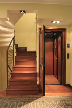 an open door leading to a hallway with wooden steps and carpet on the floor in front of it