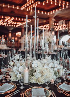 an elegant centerpiece with white flowers and candles