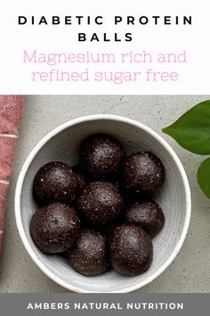 a bowl filled with chocolate covered balls next to a pink towel and green leaf on the table