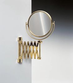 a mirror that is on the side of a wall next to some metal bars and hooks