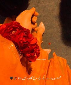 a woman's feet in orange dress with red flowers on her left side and words written in arabic