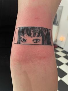 a woman's arm with an eye tattoo on it