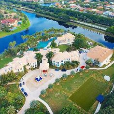 an aerial view of a home in the middle of a lake and surrounded by palm trees