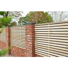 a wooden fence is shown in front of a brick wall