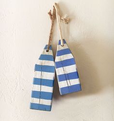 two blue and white striped wooden tags hanging on a wall