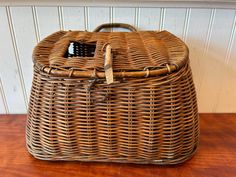 a brown wicker basket sitting on top of a wooden table